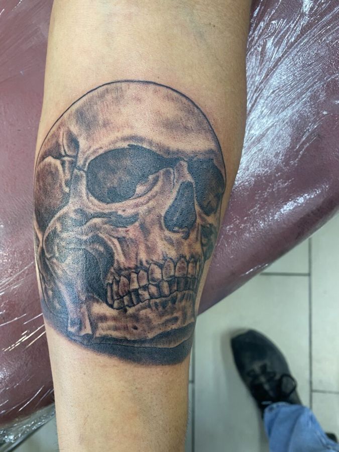 Black and grey realism skull on a forearm, by Steve