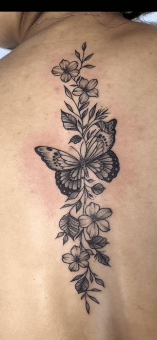 Fine-line butterflies and flowers along the spine, by Momo