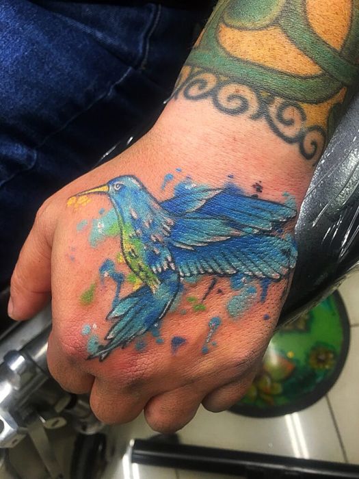 Blue hummingbird hand tattoo by Sonia