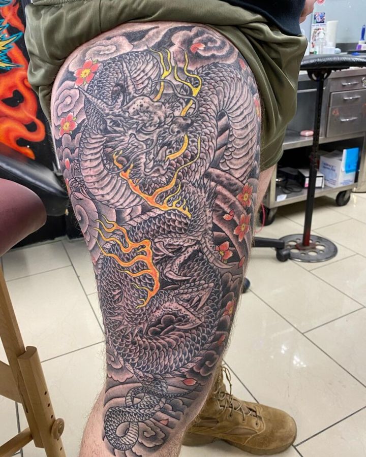 Full-leg Japanese dragon piece in black and grey with color flames, by Steve